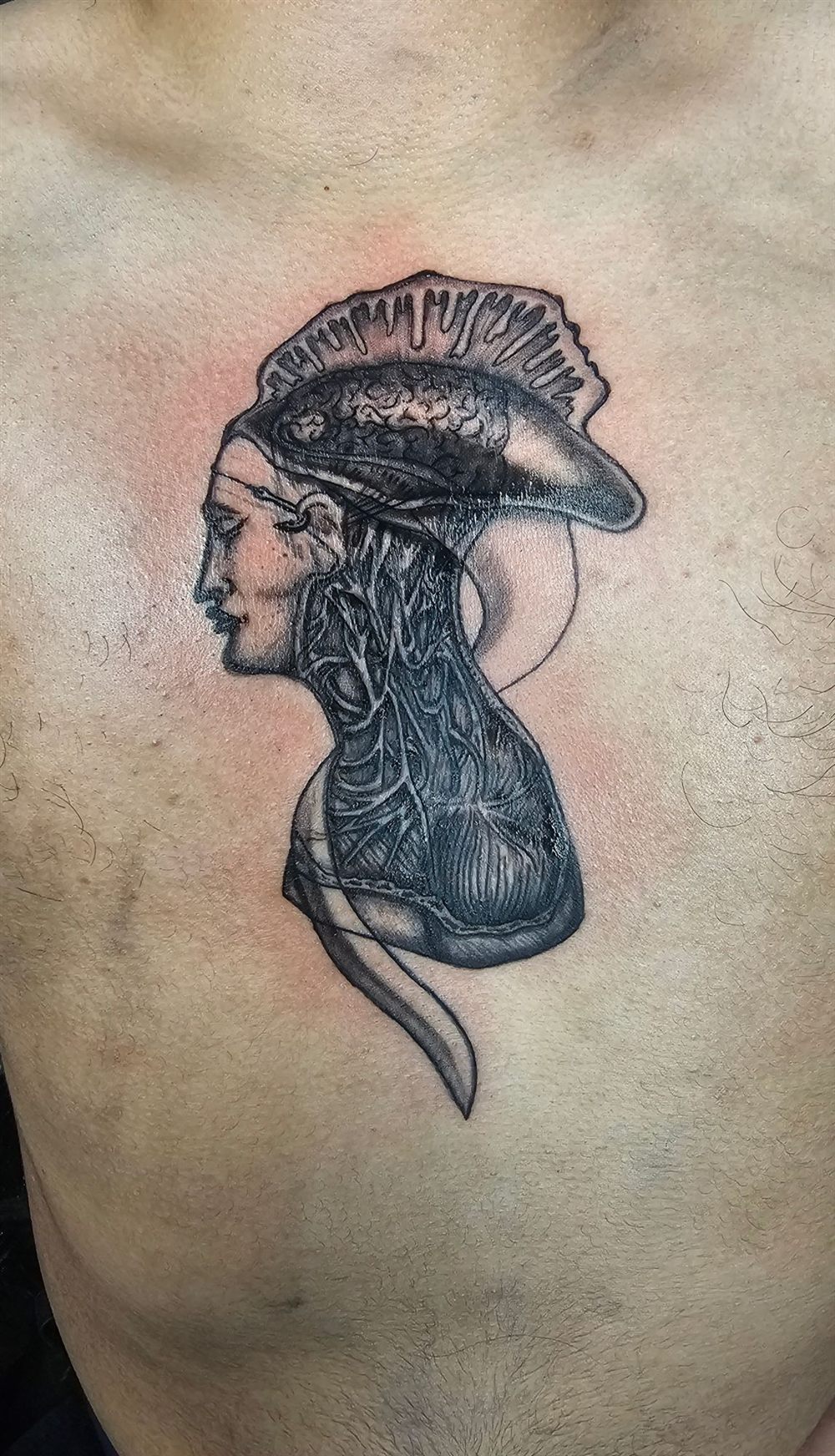Surreal blackwork profile portrait with a mushroom crown tattooed on a chest by Jungle Earth Tattoos